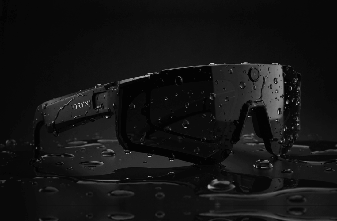 Black Oryn AI Sports Camera Glasses with water droplets on a dark background.