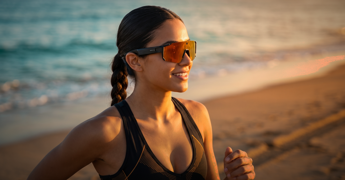 Woman running at the beach wearing smart glasses, exploring open-ear headphones for running and cycling.