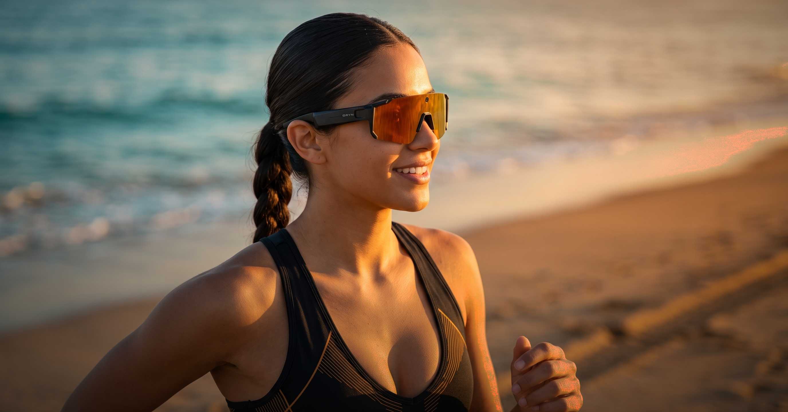 Woman running at the beach wearing smart glasses, exploring open-ear headphones for running and cycling.