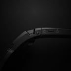 Close-up of AI sports glasses with camera showing power and camera buttons on a black background.