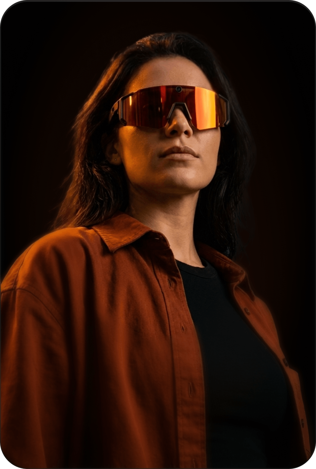 Person wearing reflective sunglasses against a dark background